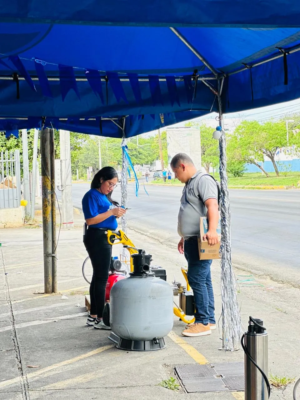 Asesora de BOMONSA atendiendo junto a un filtro de piscina en feria